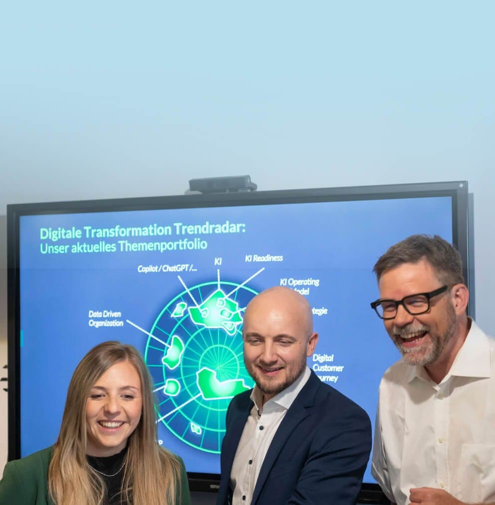 Drei Beratende lachen vor einem Bildschirm mit dem Trendradar zur digitalen Transformation