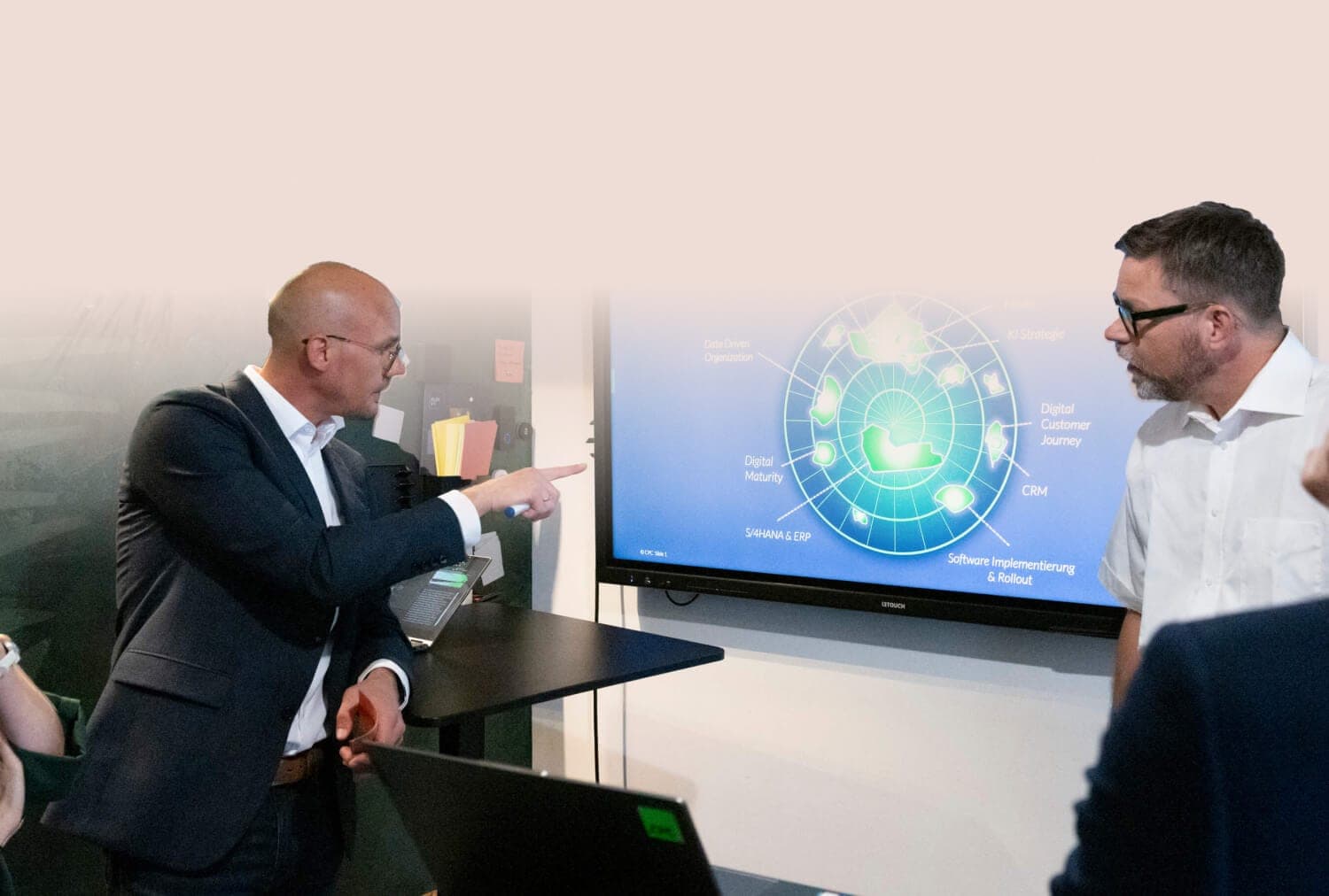 Berater zeigt einem Kollegen auf einem Bildschirm das Trendradar zu Digitalthemen